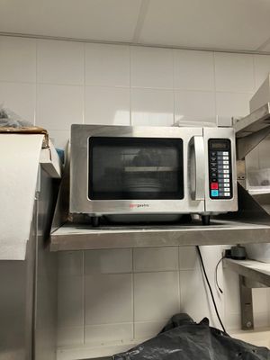 a microwave that is sitting on a shelf in a kitchen