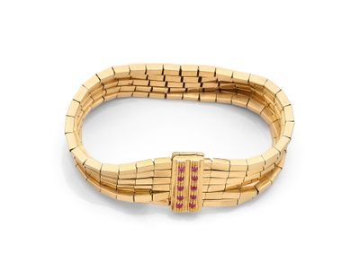 un gros plan d'un bracelet en or orné de pierres roses sur fond blanc