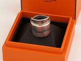 une boîte orange contenant une bague, posée sur une surface blanche