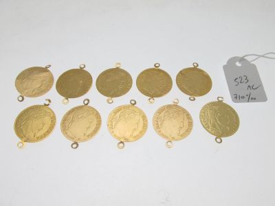 un tas de pièces d'or et d'étiquettes posées sur une surface blanche