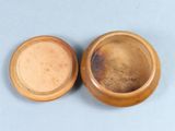pair of wooden bowls with lids sitting on a blue surface