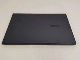 the back of a laptop with a black cover sitting on a white surface