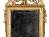 un miroir avec un cadre doré sur lequel est représenté un oiseau