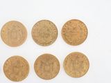four different types of gold coins on a white surface