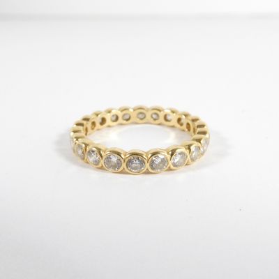 une bague en or jaune sertie de diamants blancs sur fond blanc
