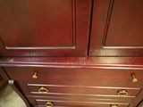 an image of a wooden dresser with brass handles