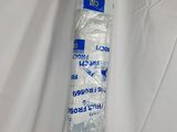 un tube de dentifrice emballé dans du plastique, posé sur un drap blanc