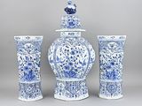 trois vases bleus et blancs et un vase surmonté d'un oiseau
