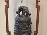 une cloche posée sur un socle dans une pièce