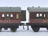 deux trains miniatures posés côte à côte sur une surface blanche