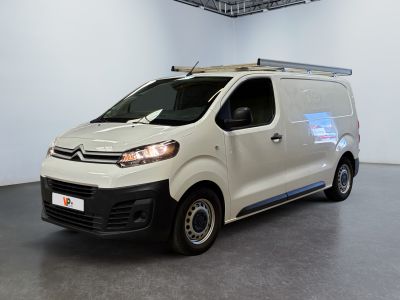 La camionnette blanche est garée dans la grande salle du bâtiment.