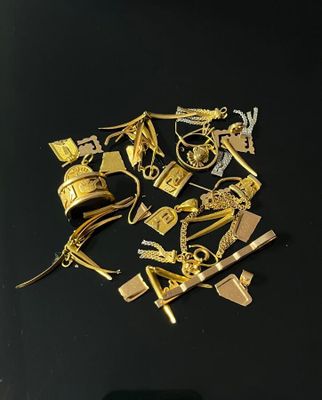 a pile of gold jewelry on a black surface