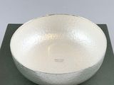 silver bowl on a black box with a white background