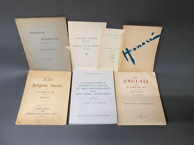 six livres posés sur une table, dont l'un est ouvert et l'autre fermé