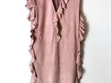 a pink dress hanging on a hanger on a wall