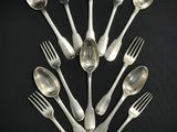 un grand nombre de cuillères et de fourchettes en argent disposées en cercle