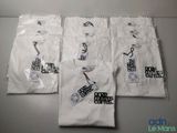 four white t - shirts with black and white logos are on a table