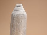 vase en céramique blanche orné d'une fleur sur fond beige