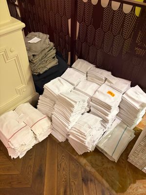 une pile de papiers posée par terre à côté d'une commode