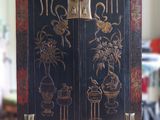 un meuble noir orné de motifs dorés dans un salon