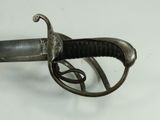 a close up of a sword on a white surface