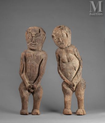 deux figurines en bois représentant un homme et une femme debout l'un à côté de l'autre