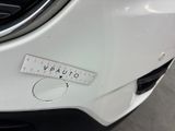 a close up of a white car with a measuring tape on the front of it