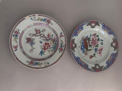 two plates with floral designs on them are sitting on a table