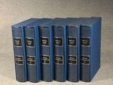 quatre livres bleus empilés les uns sur les autres sur une table