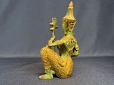 statue of a woman sitting on a rock with a bird in her hand