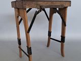 une petite table en bois ornée de lanières noires