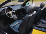 the interior of a yellow sports car with black leather seats