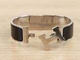 silver and black enamel bracelet with a cross on it