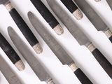 many knives that are lined up on a table
