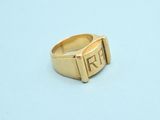 a close up of a gold ring with the letter r on it