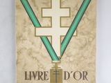 un vieux livre orné d'une croix et entouré d'un ruban