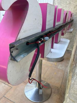 un banc rose et blanc orné d'une bande rayée noire et blanche