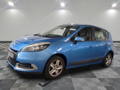 the blue car is parked on a checkered floor in the garage