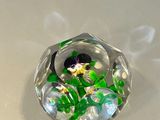 a glass object with flowers inside of it on a table