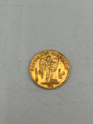 l'image d'une pièce d'or posée sur une surface blanche