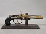 a close up of a toy gun on a stand on a white surface