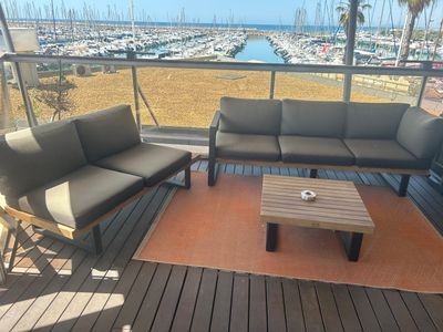 une photo d'un balcon avec des canapés et une table basse