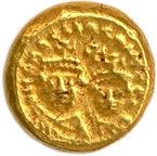 une pièce d'or sur une surface blanche avec un fond blanc