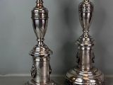 pair of silver plated candlesticks on stand on grey background
