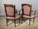 two wooden chairs with red and white striped upholstered seats