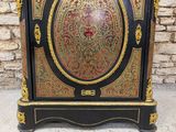 a black and gold cabinet with a clock on top of it