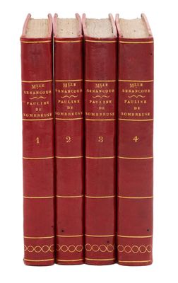 trois livres rouges superposés sur une surface blanche