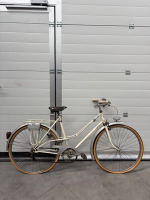 un vélo blanc garé à côté d'une porte de garage