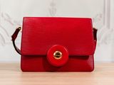 a close up of a red purse on a wooden table