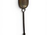 an old spoon with a handle on a white surface